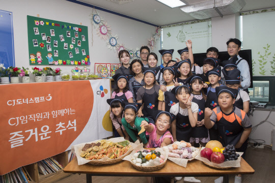 지난 22일 오후 서울 강서구의 한 지역아동센터에서 봉사활동에 참여한 CJ그룹 임직원들이 어린이들과 함께 명절 음식을 만든 후 기념촬영을 하고 있다. <CJ그룹 제공>